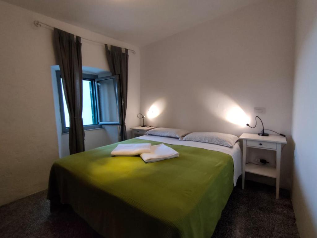 una camera da letto con un letto e due asciugamani di appartamento a Fosdinovo a Fosdinovo