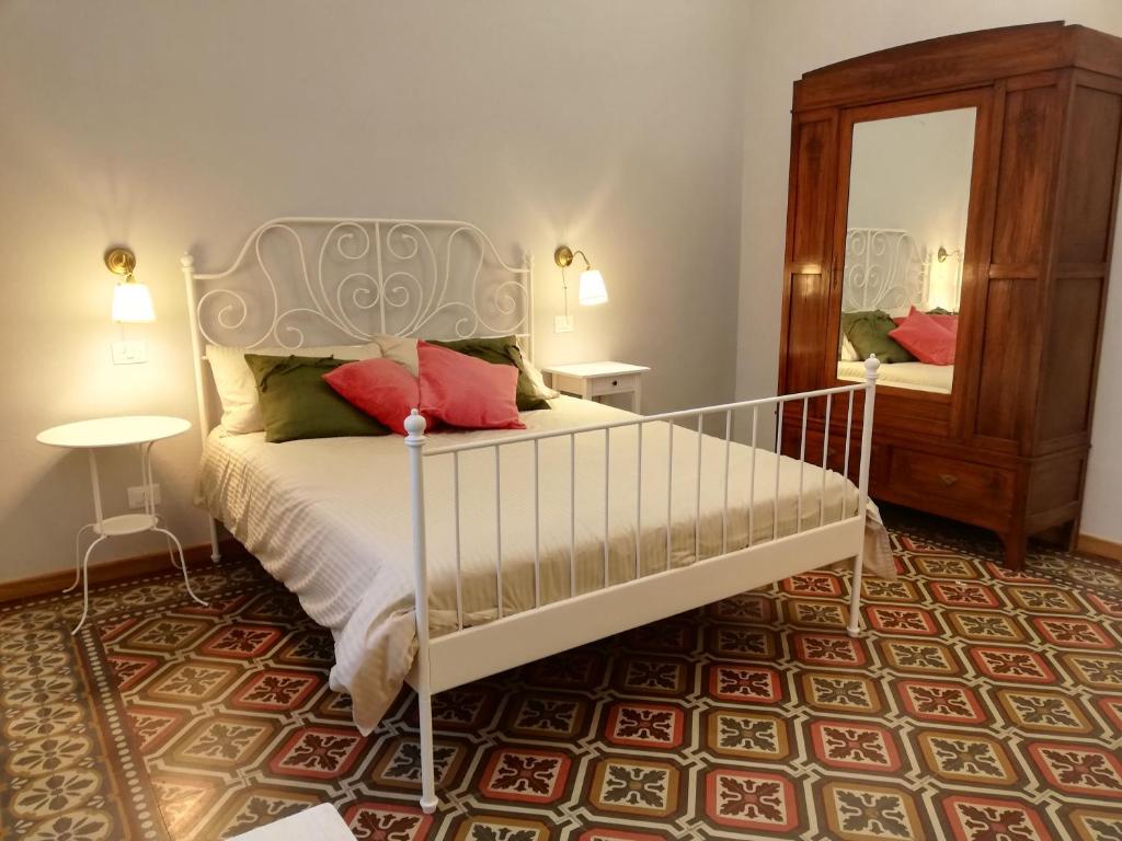 a bedroom with a white bed and a mirror at Casa Ridolfi Holiday Home -Una terrazza sui giardini di Pisa in Pisa