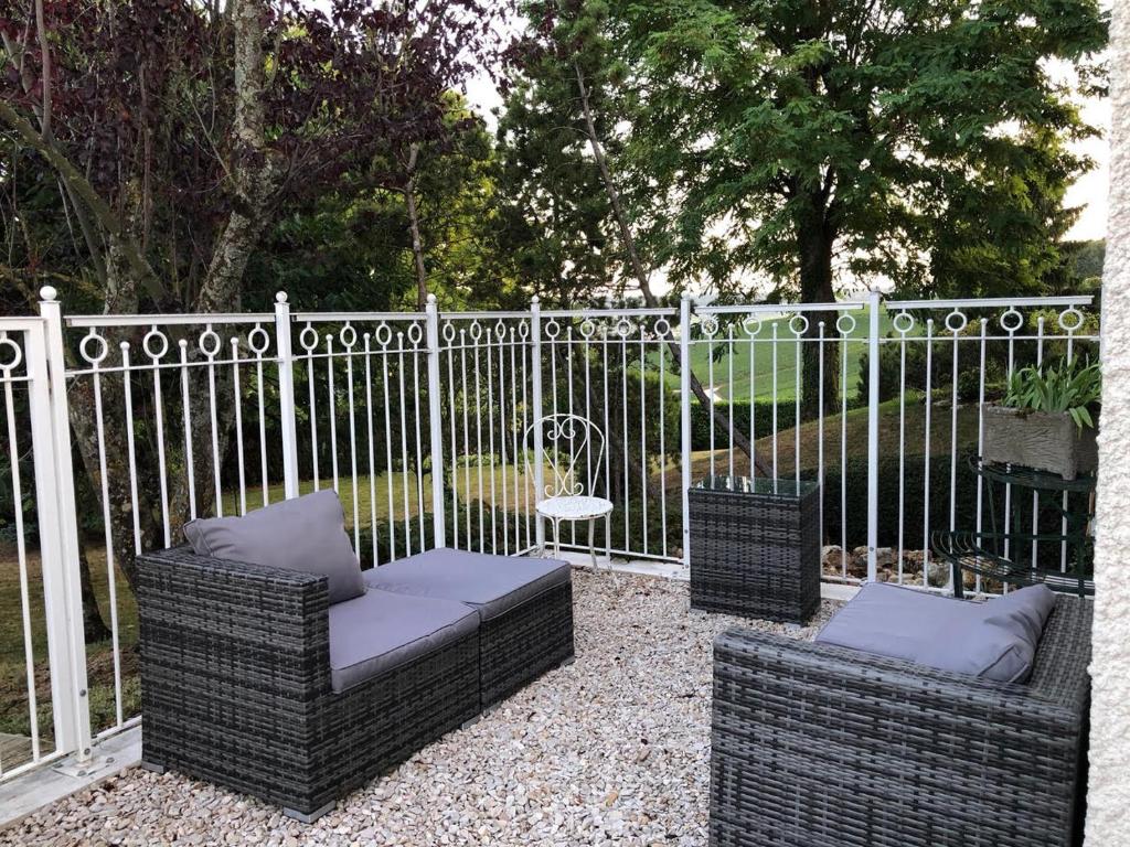 dos sillas de mimbre sentadas frente a una valla en Le Clos des Moulins en Hautvillers