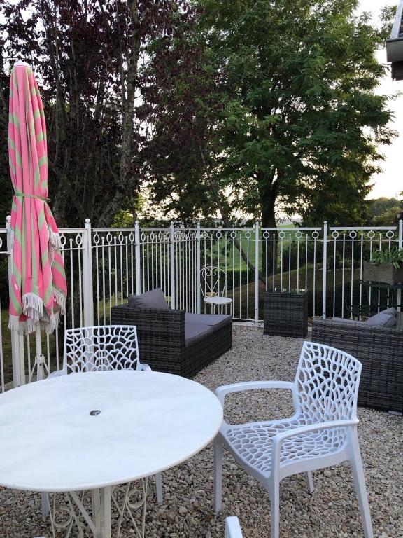 une table et deux chaises ainsi qu'une table et des chaises blanches dans l'établissement Le Clos des Moulins 2 rue des cotes de l'Héry no rue porte d'en bas, à Hautvillers