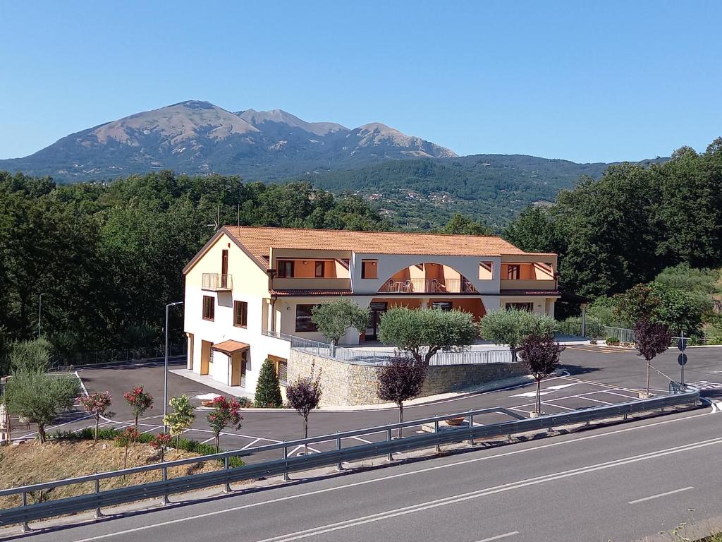 uma casa ao lado de uma estrada com uma montanha em Hotel Ristorante Villa Terry em Lauria Inferiore