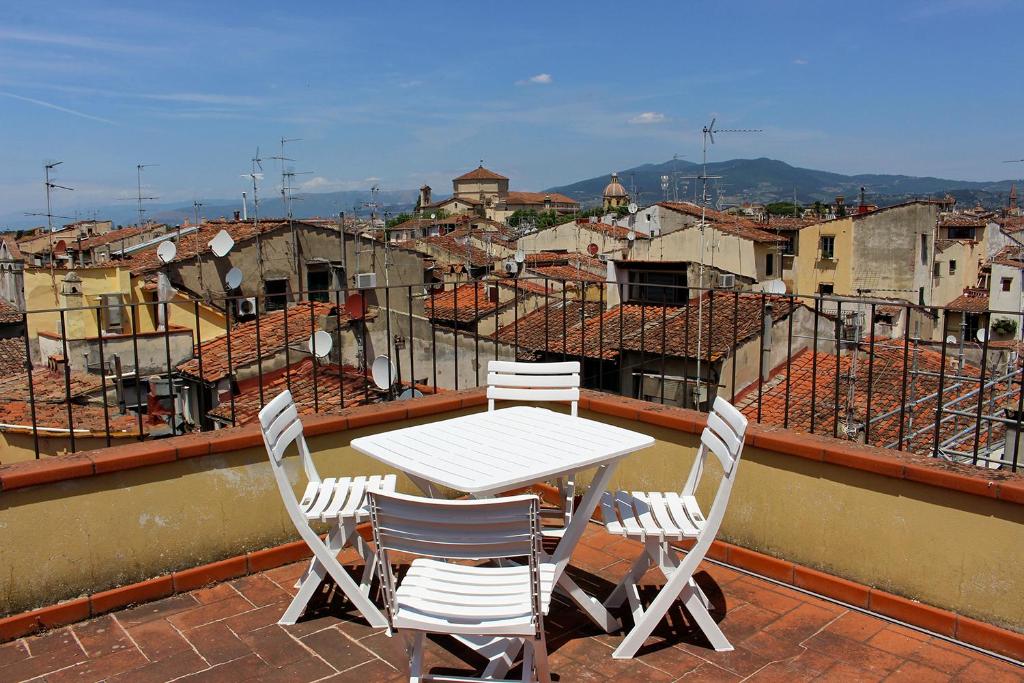 a table and chairs on the roof of a city at Roommo Oltrarno in Florence
