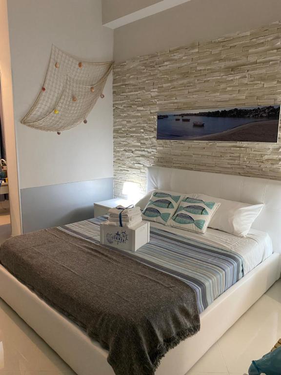 um quarto com uma cama com uma parede de tijolos em Al porticciolo em Salerno
