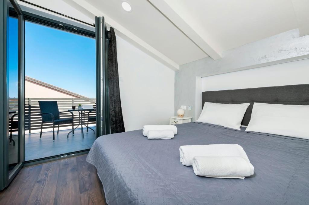 a bedroom with a large bed and a balcony at Apartment Arian in Rovinj