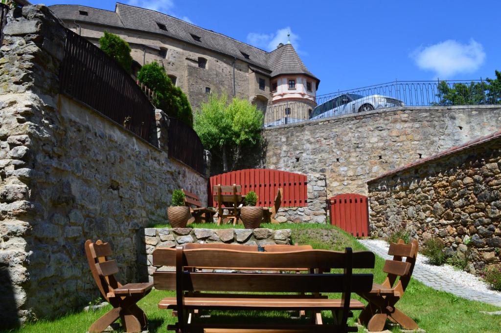 a stone wall with two benches in front of a building at Egrensis Apartments in Loket