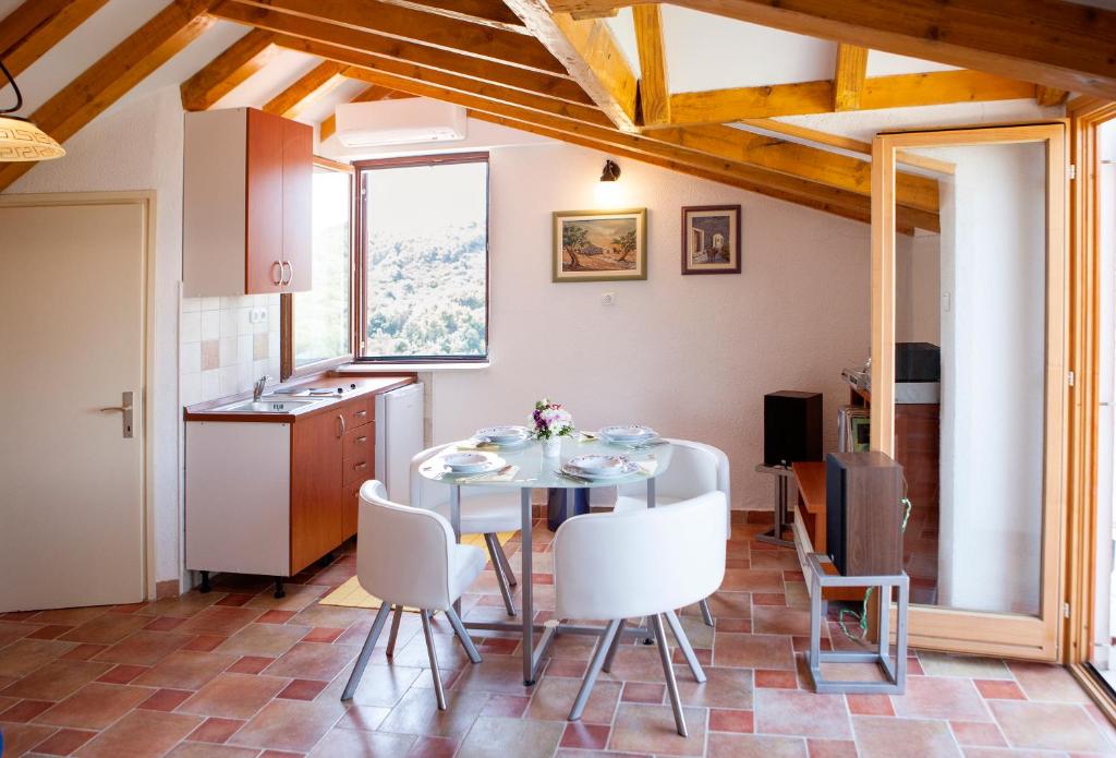 a kitchen and dining room with a table and chairs at A2 - studio with balcony just 3 min to the beach in Okrug Donji