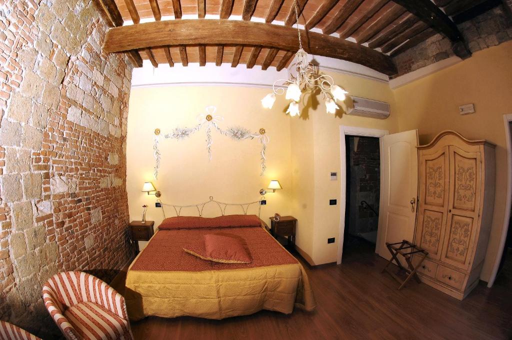 a bedroom with a bed and a brick wall at Hotel Di Stefano in Pisa