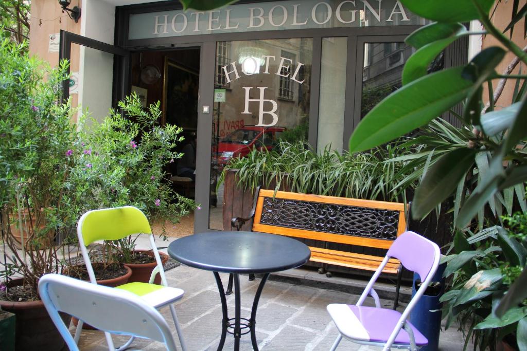 une table et des chaises devant un bâtiment dans l'établissement Hotel Bologna, à Gênes