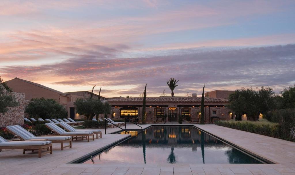 a swimming pool with lounge chairs and a building at Can Ferrereta in Santanyi