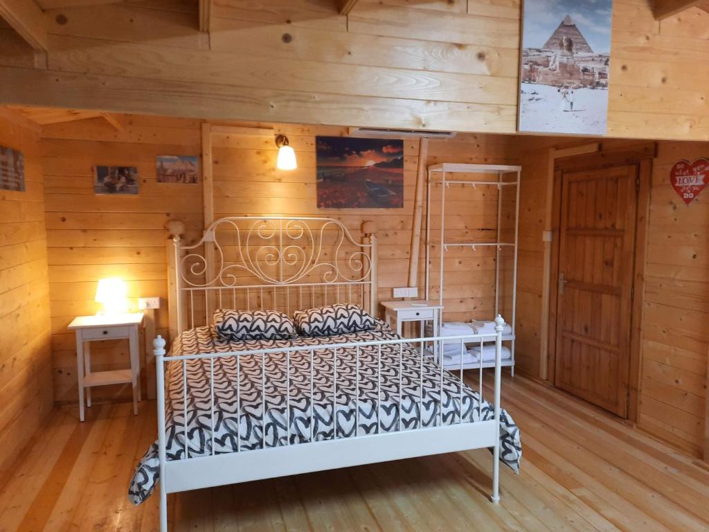 a bedroom with a bed in a room with wooden walls at Cyprus Glamping Park in Ayios Theodhoros