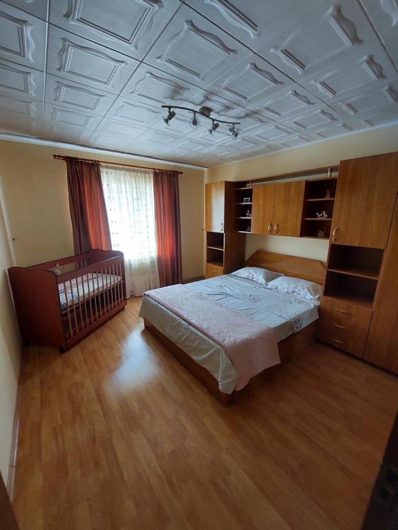 a bedroom with a bed and a crib in it at Apartament Natalie&Helen in Zărneşti