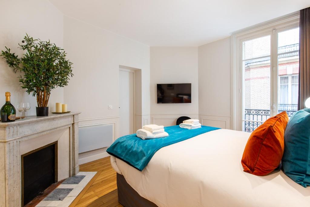a bedroom with a large bed and a fireplace at CMG BASTILLE &#47; GARE DE LYON 2 in Paris