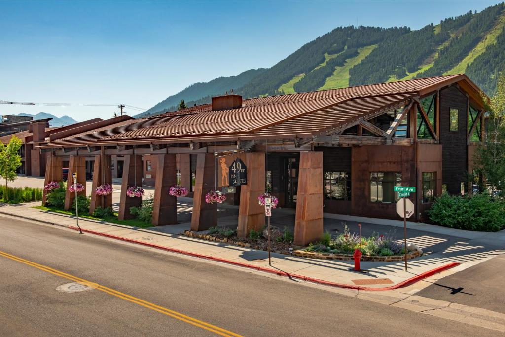 a building on the side of a street with a mountain at 49'er Inn & Suites in Jackson