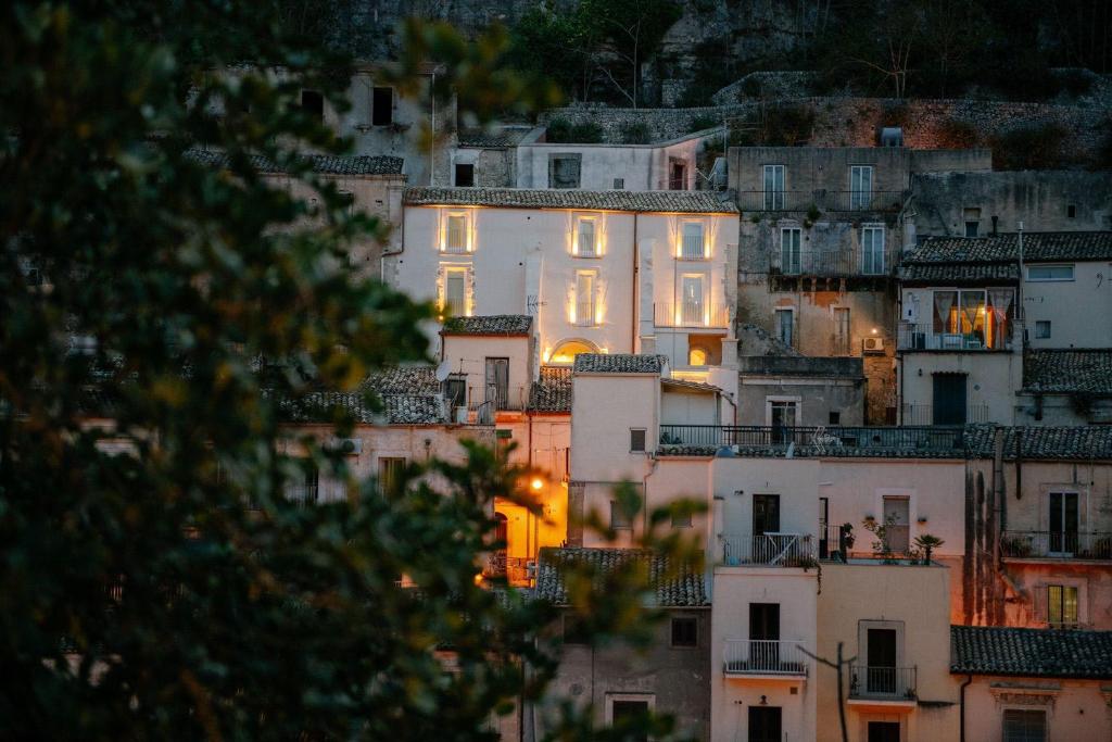 um grupo de casas brancas numa colina à noite em IBLA ROOMS em Ragusa