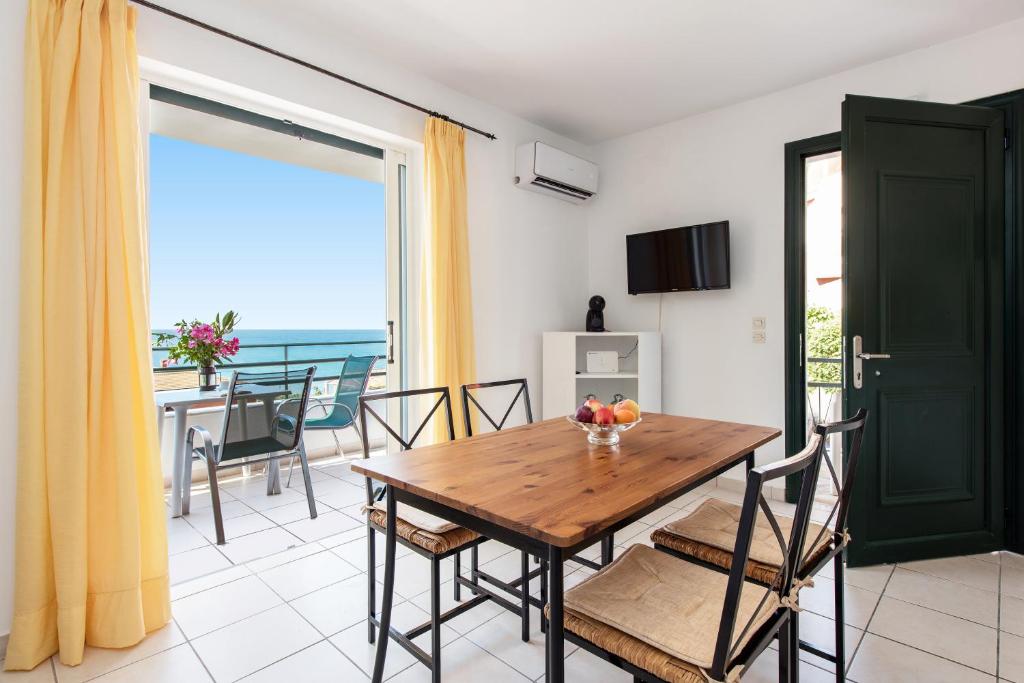 a dining room with a table and a view of the ocean at Corfu Amboti Apt in Glyfada