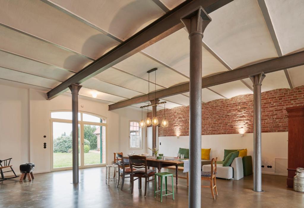 a dining room and living room with a brick wall at re~barn - Modern Country Stay in Essel