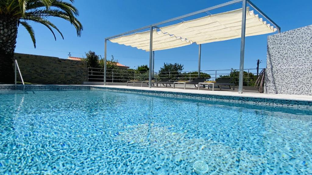 a large swimming pool with a canopy over it at Moderna by Check-in Portugal in Quarteira
