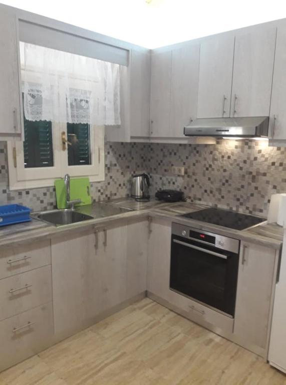 a kitchen with white cabinets and a stove top oven at Katerina Studios in Paleokastritsa