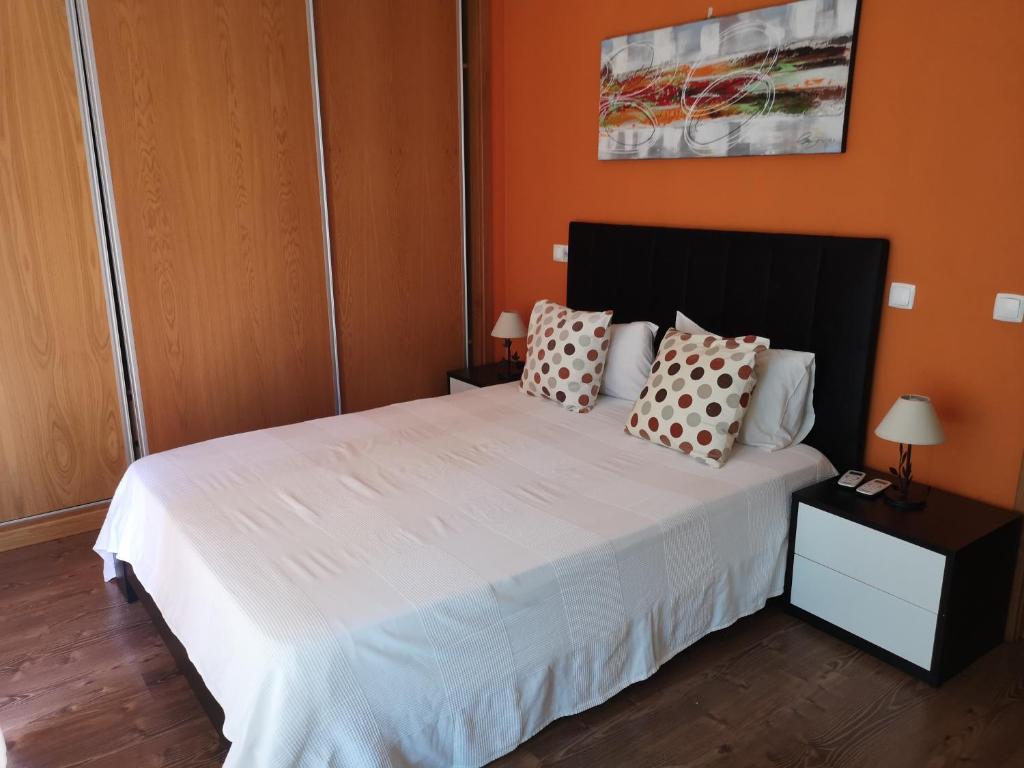 een slaapkamer met een groot wit bed met kussens bij Villa Arade Ferragudo in Ferragudo