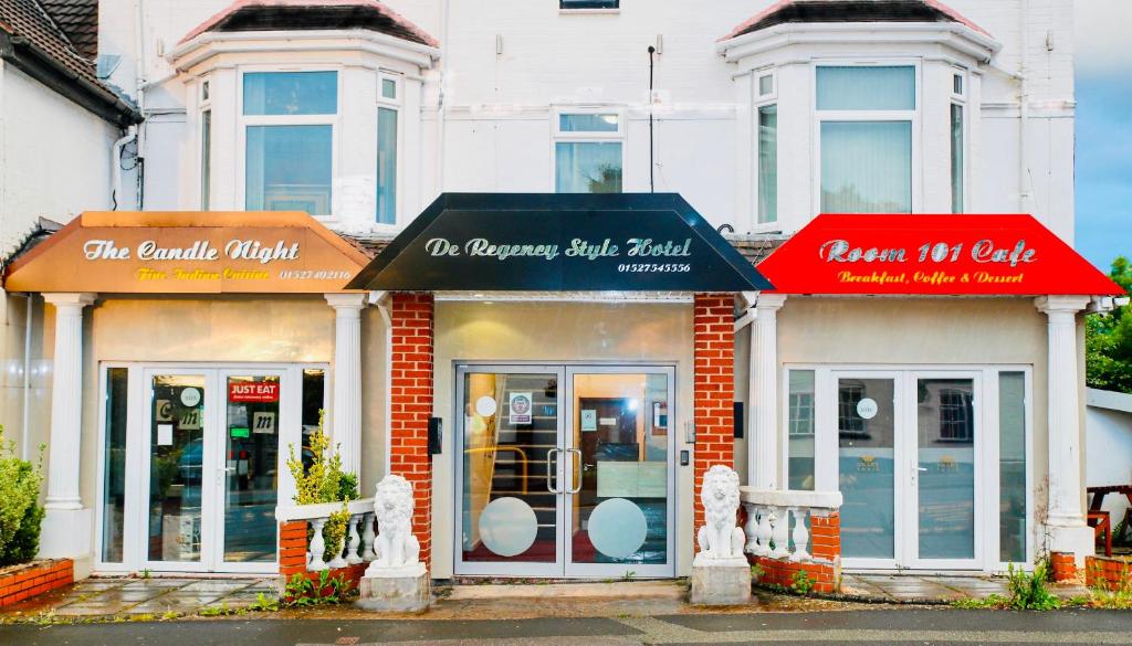 un magasin avec des auvents rouges dans une rue dans l'établissement De Regency Style Hotel, à Redditch