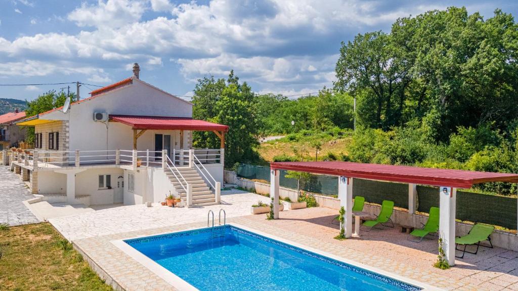 a villa with a swimming pool and a house at Holiday House Ivan in Neorić