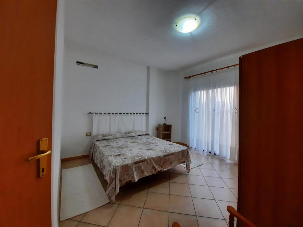 een slaapkamer met een bed in een witte kamer bij Domo Vèdele in Galtellì
