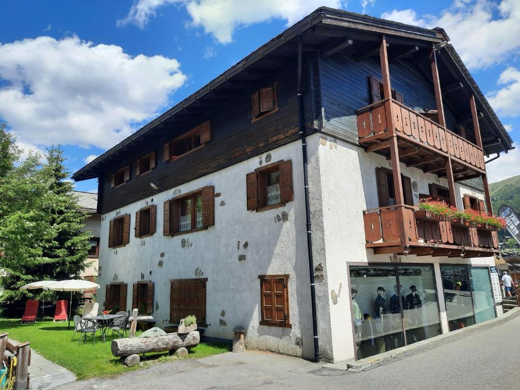 un edificio con balcón en la parte superior en Bait d'Armin - Sport Azzurro en Livigno