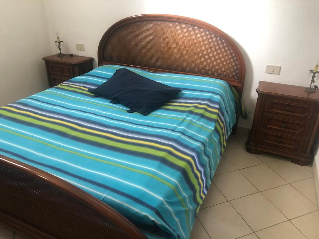 1 cama con manta de rayas azul y amarilla y mesita de noche en Fronte Mare, en Albissola Marina
