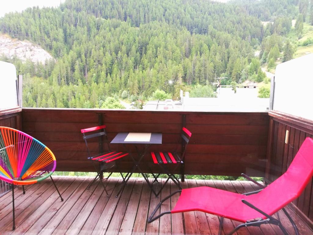 una mesa y sillas en una terraza con vistas en Pra-Loup 1600, Front de Neige en Pra-Loup