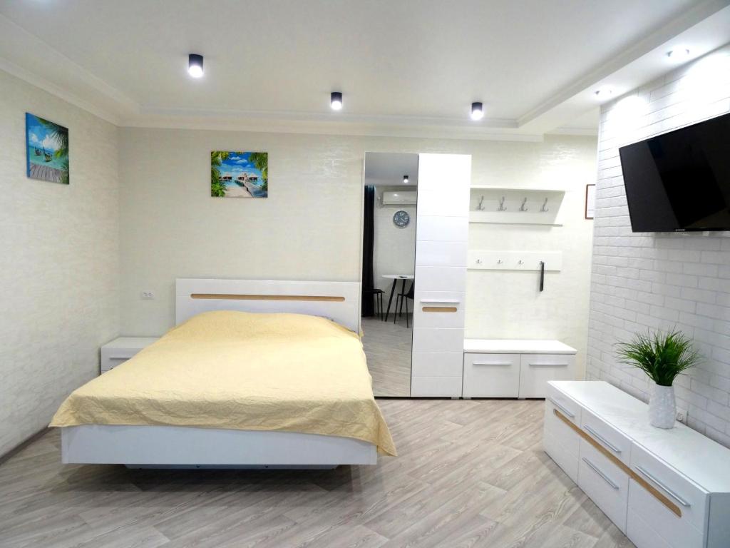 a white bedroom with a bed and a bathroom at Apart Gagarina 7 in Kropyvnytskyi