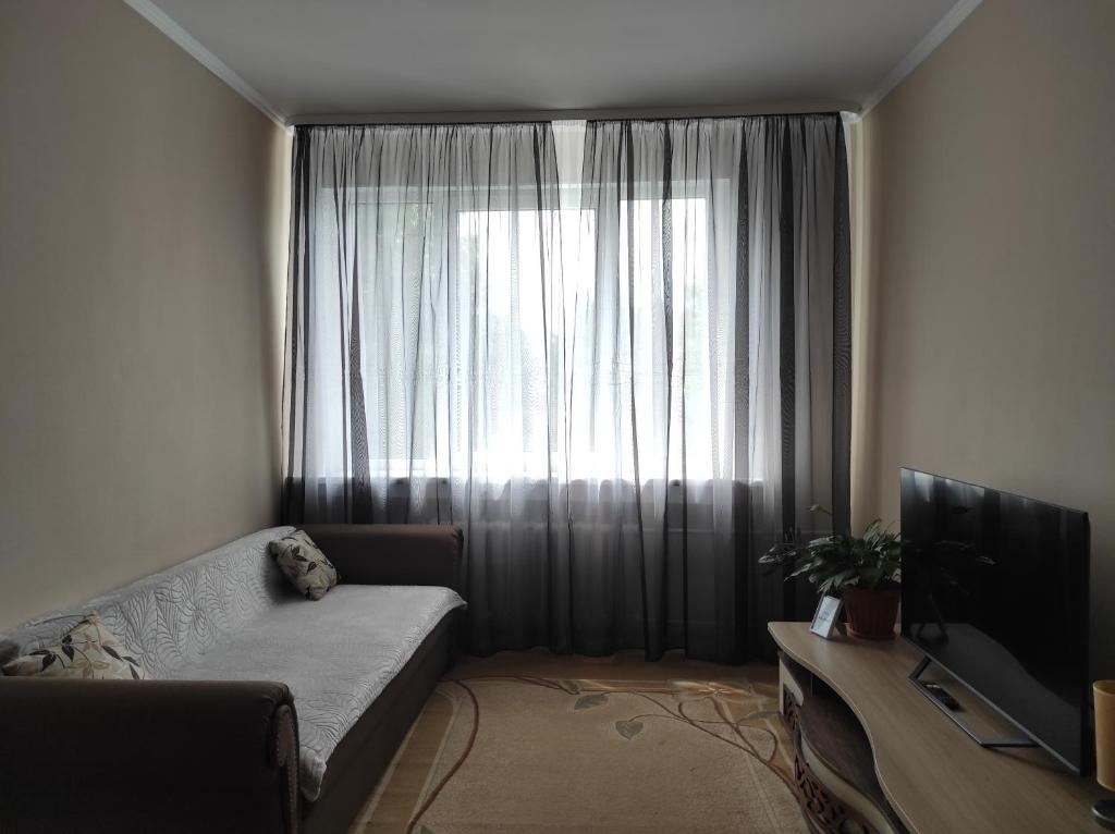 un soggiorno con divano e una grande finestra di NarvaCenter a Narva