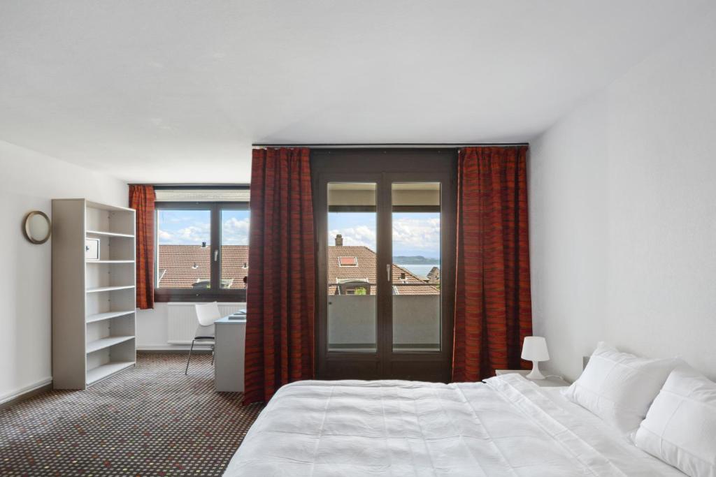 Una cama o camas en una habitación de Neuchâtel City Hôtel