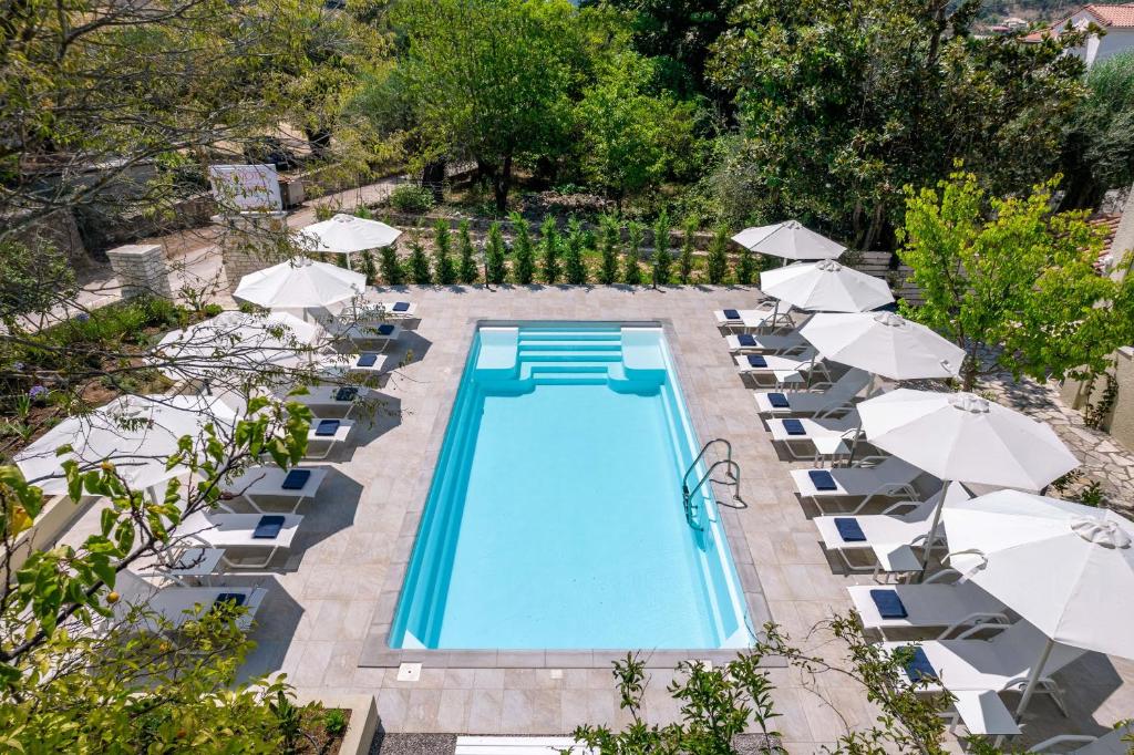 an overhead view of a swimming pool with chairs and umbrellas at Syvota Gardens in Sivota