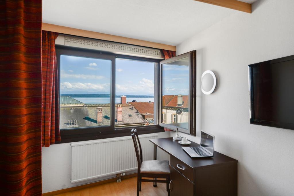 Una televisión o centro de entretenimiento en Neuchâtel City Hôtel