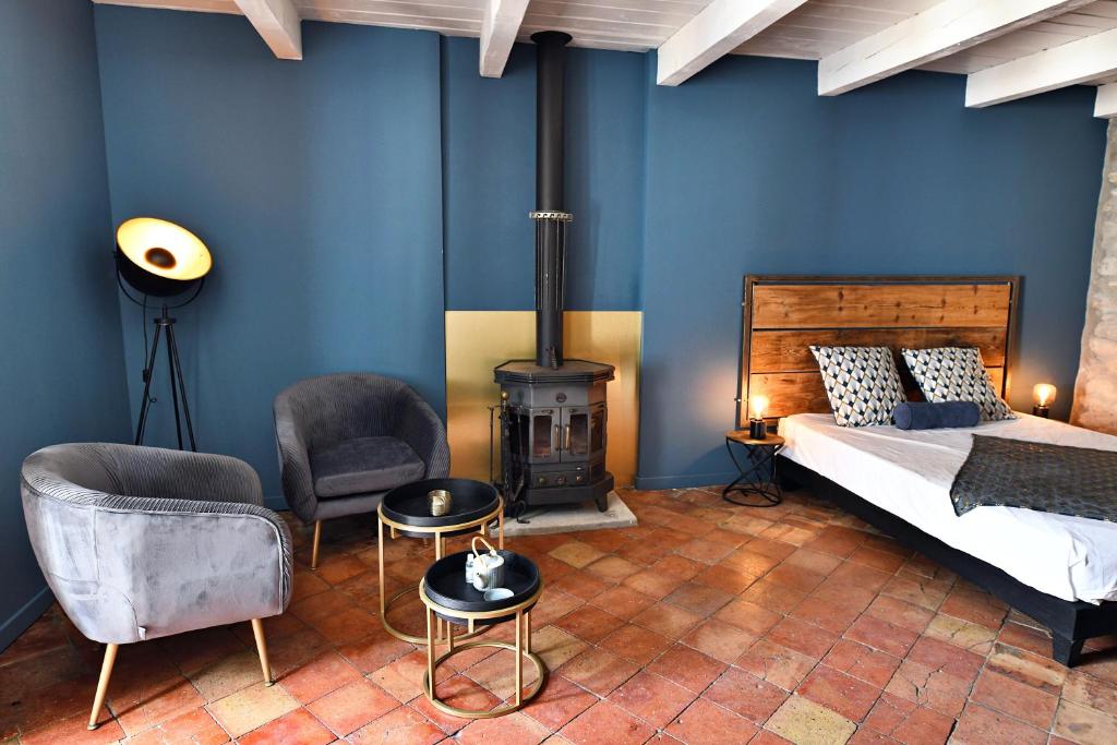 una camera con letto e stufa a legna di Le Bruit de l'Eau (Chambre La Suite) a Labeaume