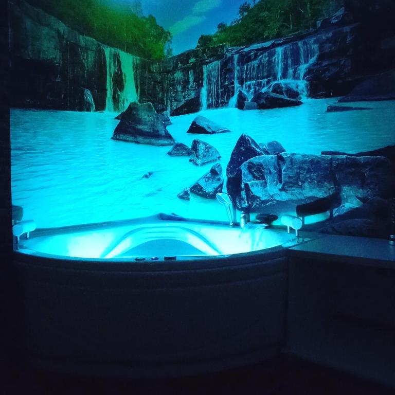 a hot tub in front of a waterfall at a water park at Delux Apartmani Bulevar in Sarajevo