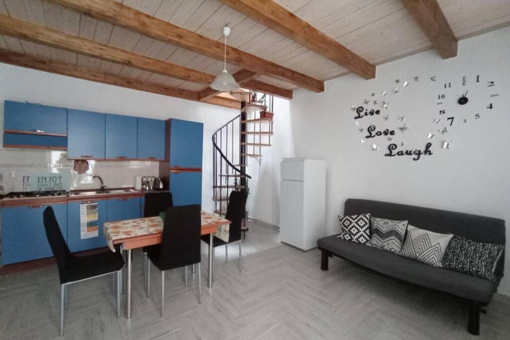 - une cuisine et un salon avec une table et une horloge murale dans l'établissement B&B la piccola maison, à Ploaghe