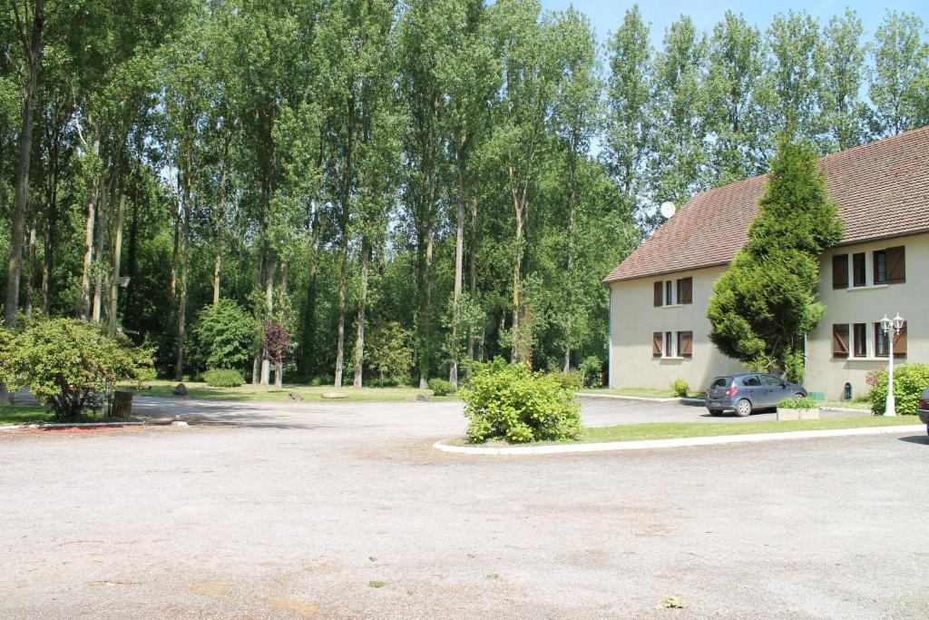 ein Parkplatz vor einem Haus in der Unterkunft Hôtel La Peupleraie in Nampont-Saint-Martin