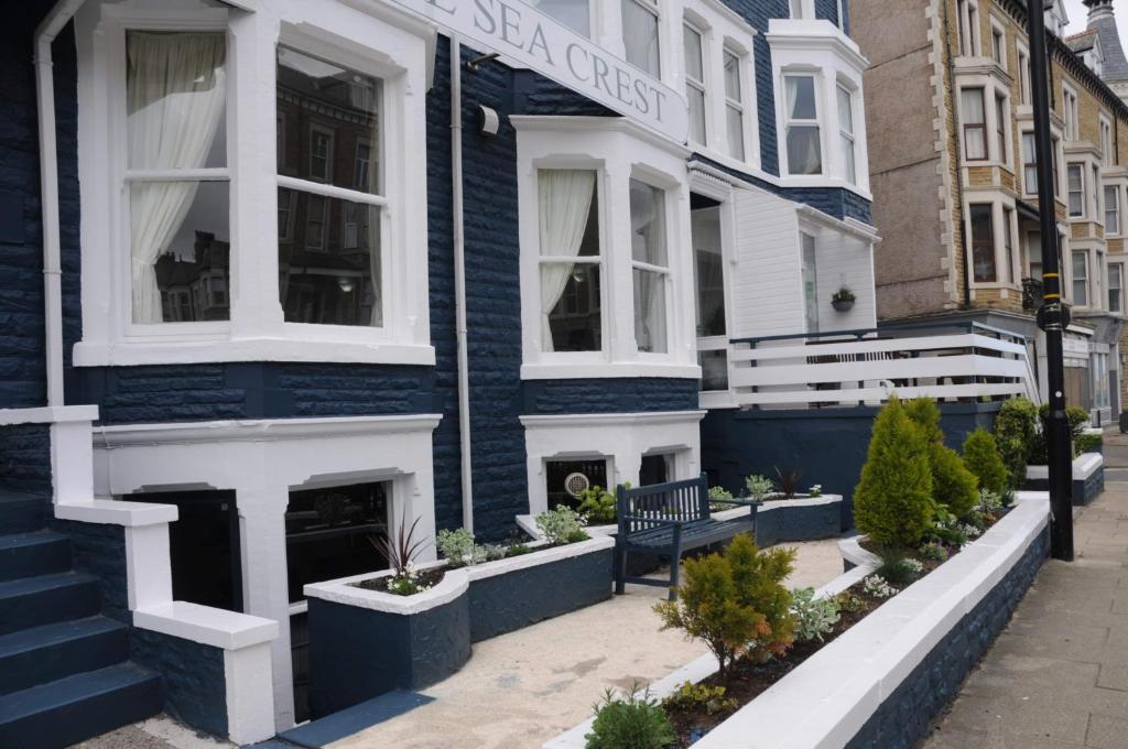 a blue and white house with a bench in front of it at The Sea Crest in Morecambe