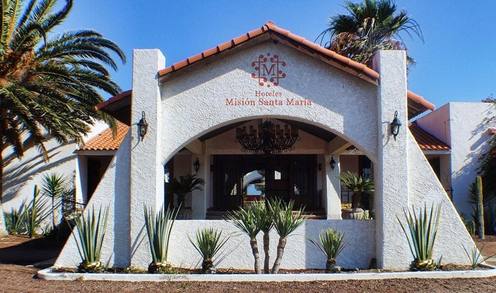 a building with a sign in front of a restaurant at HOTEL MISION SANTA MARIA in San Quintín