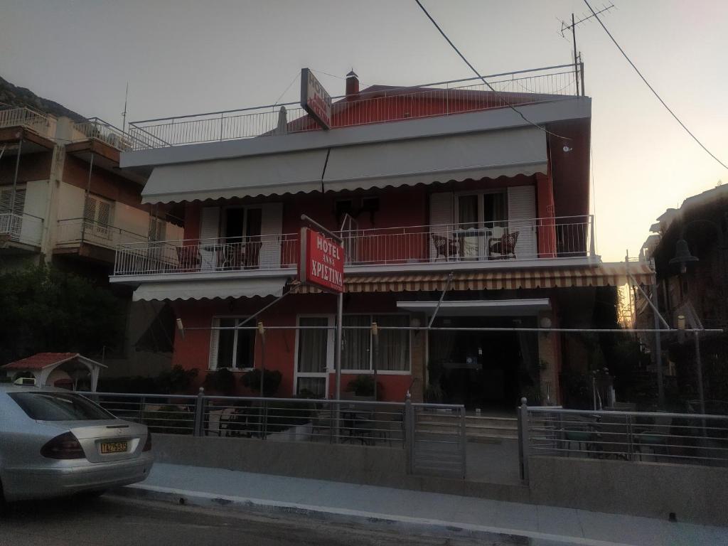 a red building with a car parked in front of it at Anna Christina in Kamena Vourla