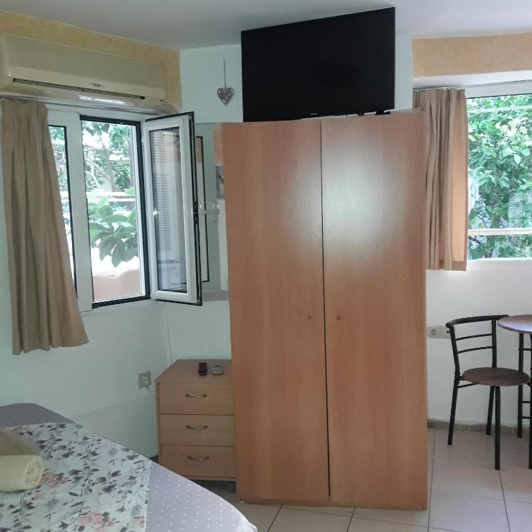 duża drewniana szafka w sypialni z oknami w obiekcie Ground Floor Studio Galini w Retimnie