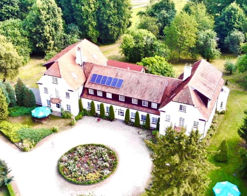 an aerial view of a large house with a solar roof at Pałac Wojciechy in Wojciechy