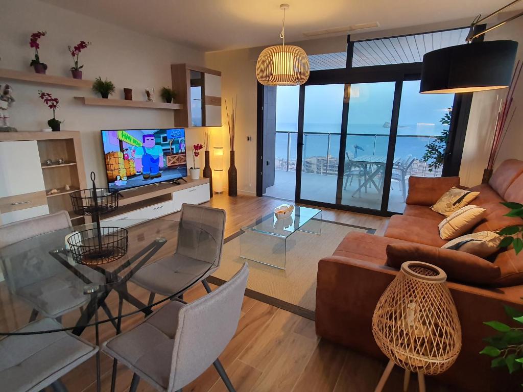 een woonkamer met een bank en een tv bij Sunset Waves Benidorm by KalmaRent in Benidorm
