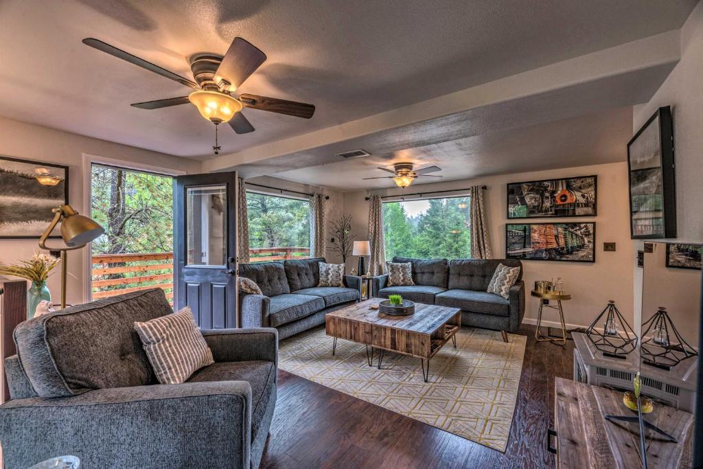 a living room with couches and a ceiling fan at On the Rocks - A Modern Home with Decks and Views in Cloudcroft