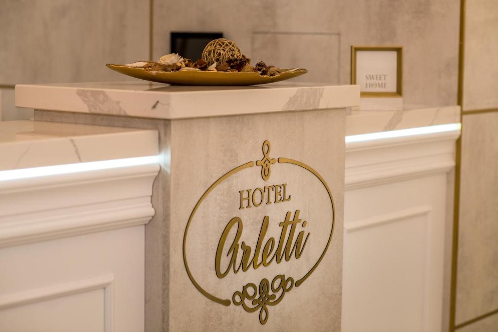 un panneau sur un comptoir avec une plaque de nourriture dans l'établissement Arletti Hotel, à Ruse