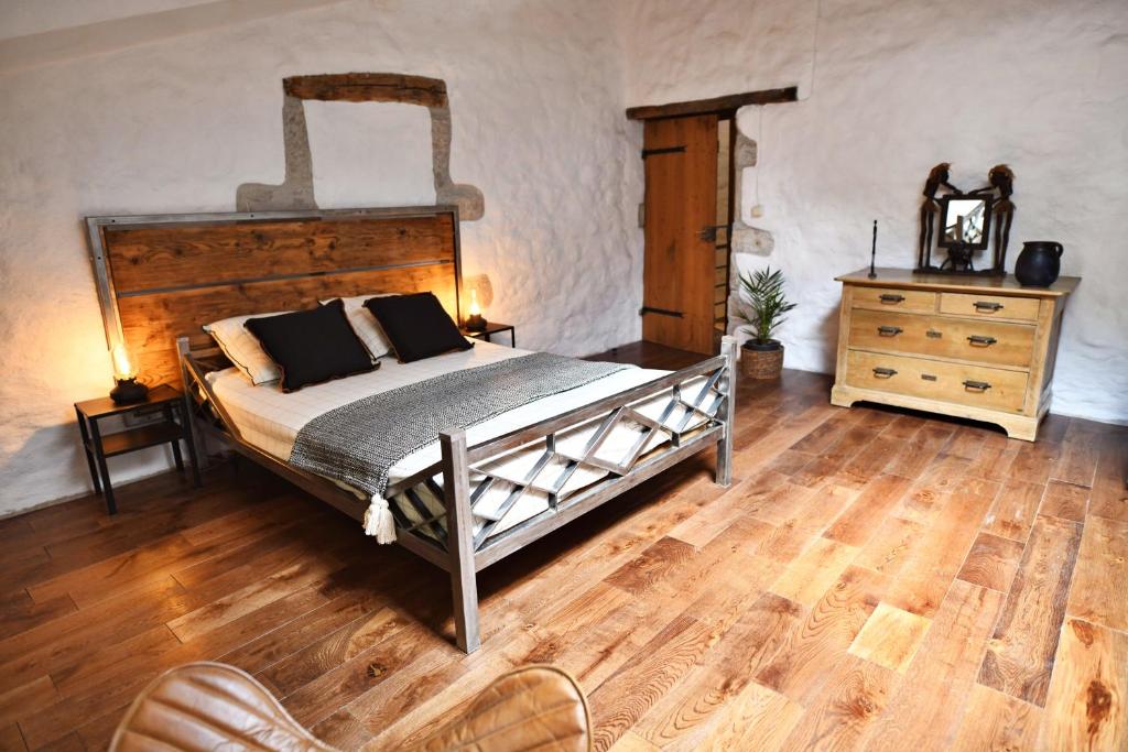 a bedroom with a large bed and a wooden floor at Le Bruit de l'Eau (Chambre Loft) in Labeaume