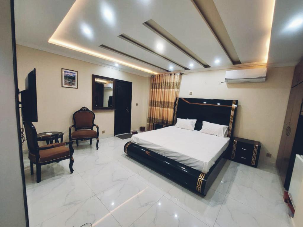 Hotel White Pearl في لاهور: غرفة نوم فيها سرير وكرسي