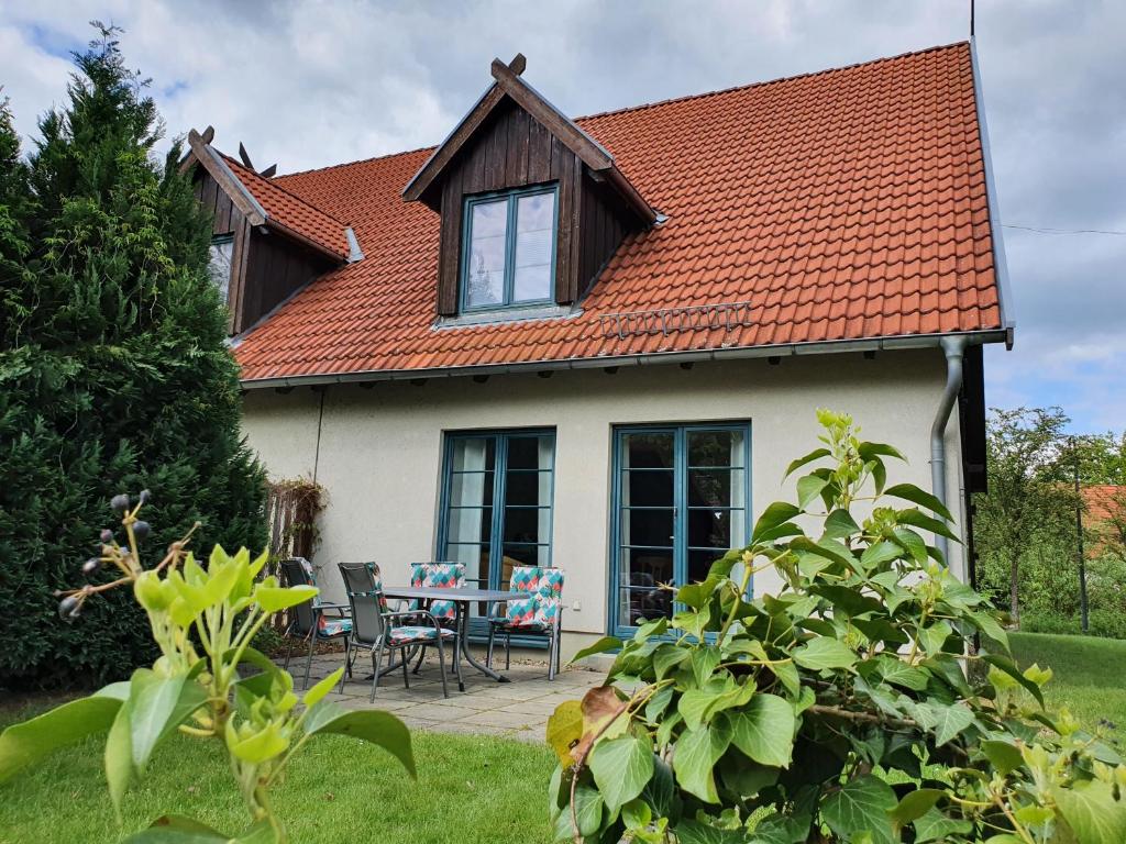 een huis met een oranje dak en een tafel en stoelen bij Ferienhaus Igel in Burg