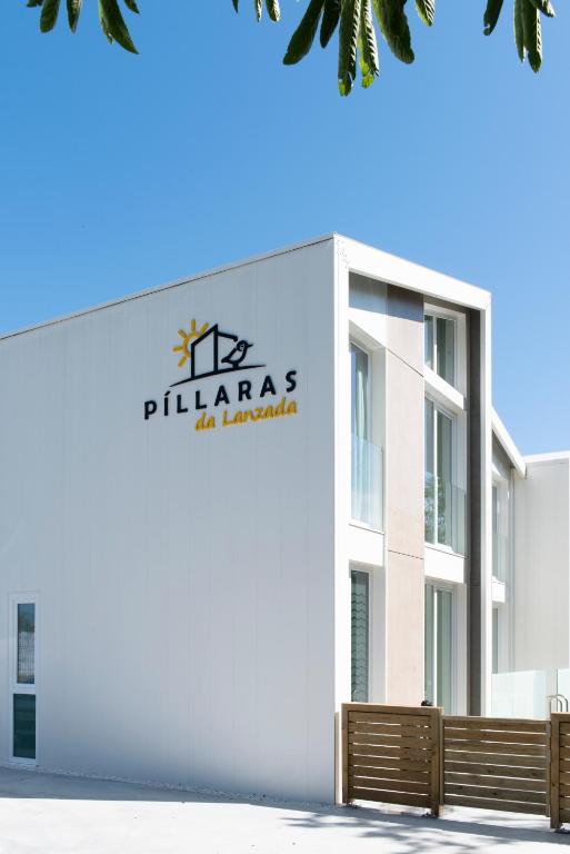 a building with a sign on the side of it at Píllaras da Lanzada in A Lanzada